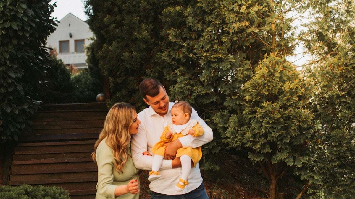 a man and woman holding a baby in their arms